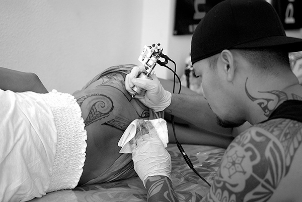 David “Boze” Kapoi tattooing a client