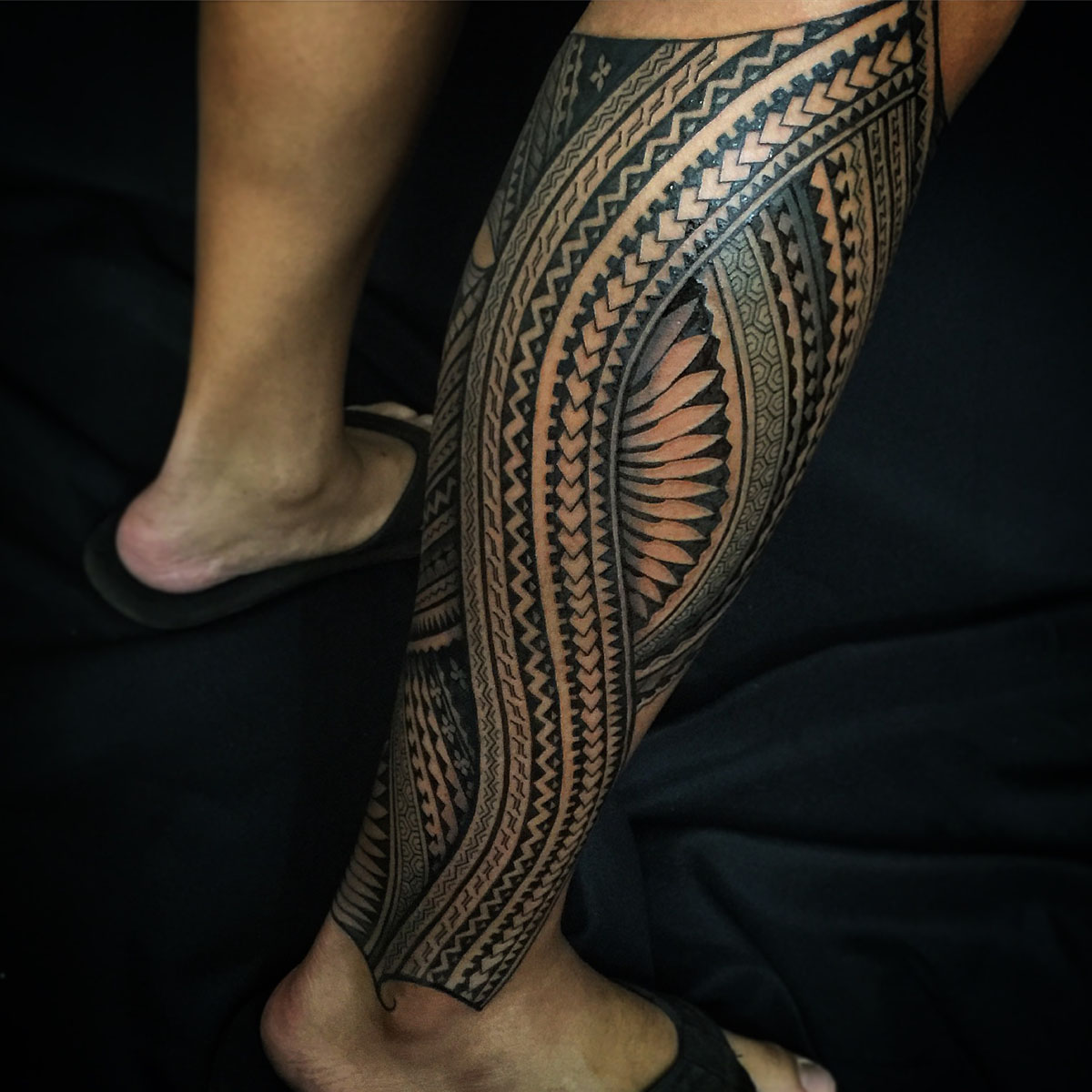 Black and gray geometric tattoo extending from calf to ankle